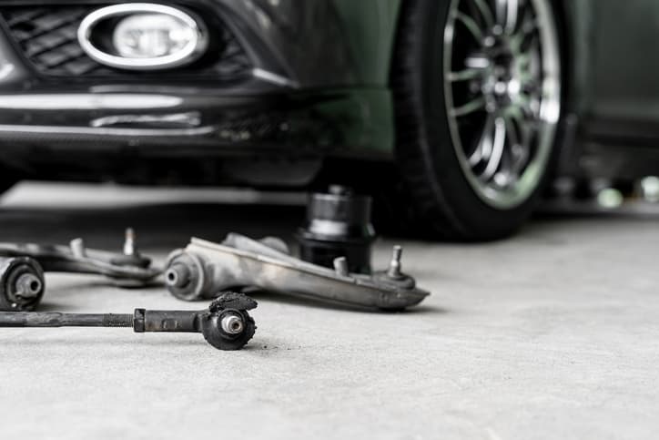 Fahrwerk und Querlenker auf Werkstattboden